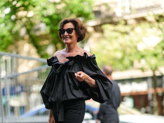 Ines de la Fressange trägt einen kurzen, stufigen Bob und ein schwarzes Outfit. | © Getty Images / Edward Berthelot