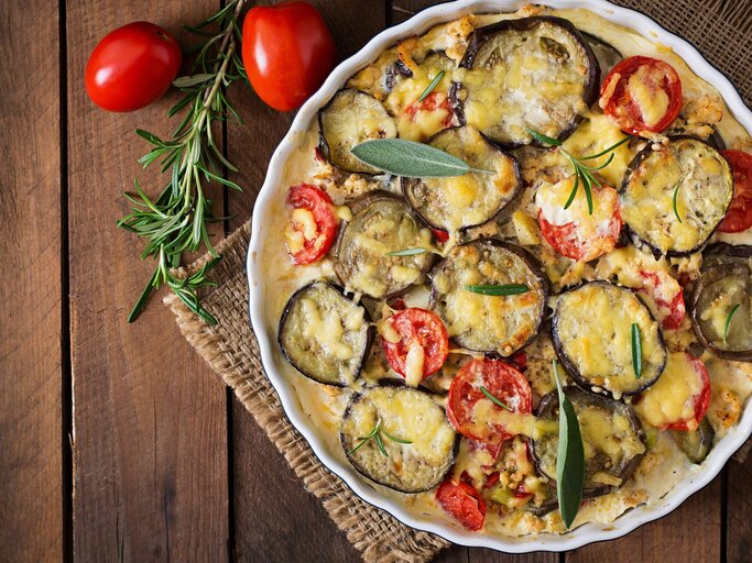 Eine Auflaufform mit veganem Kartoffelgratin und frischen Kräutern | © Getty Images/Elena_Danileiko