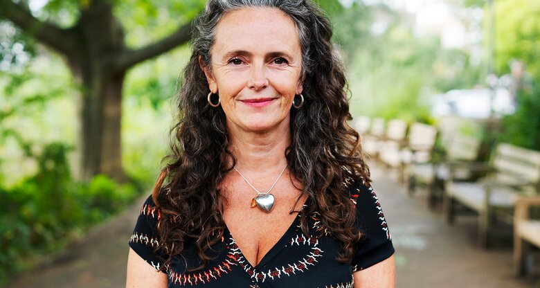 Eine Frau ist in der Natur und lächelt | © GettyImages/Tim Robberts