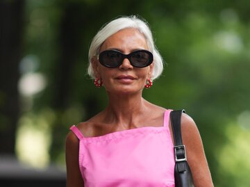 Streetstyle von Grece Ghanem mit grauen Haaren, pinkem Kleid und schwarzer Sonnenbrille | © Getty Images/Edward Berthelot