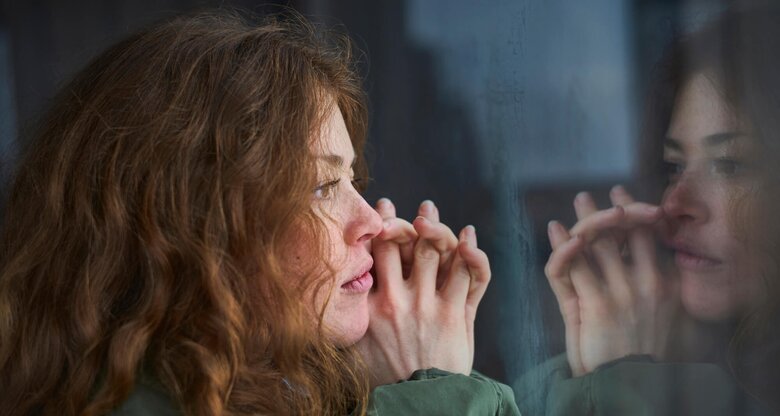 Frau blickt nachdenklich aus dem Fenster | © gettyimages.de /  Justin Case