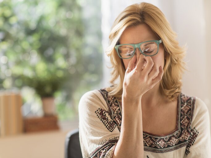 Reife Frau ist gestresst und körperlich erschöpft | © Getty Images/	Tetra Images