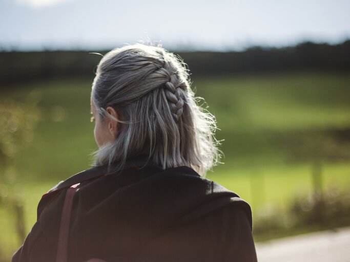 Frau mit grauen Haaren hat einen geflochtenen Zopf | © GettyImages/Johner Images